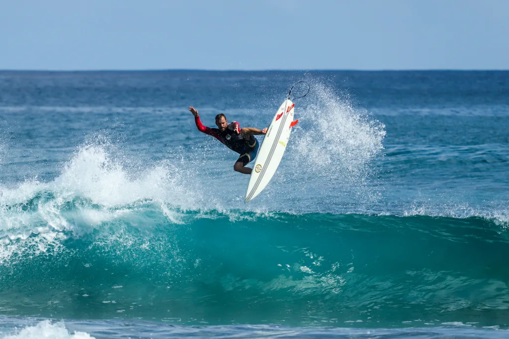 A surfer riding a wave off the Orange County coast